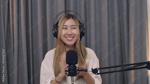 Smiling of Young Asian woman influencer recording a vlog using podcast microphone for vlogging and recording podcast live streaming content for social media.
