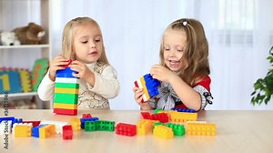 Two little sisters playing with the constructor