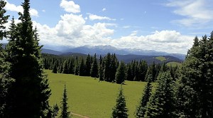 Flying Over A Field and Into The Mountains 4k Royalty Free Stock Video
