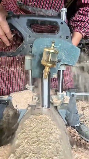 operating a specialized chain mortiser machine to cut deep rectangular holes in a large wood beam