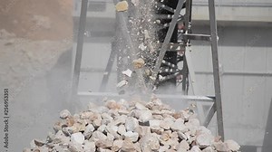 Quarrying of limestone in a quarry. Crushed stones pouring from conveyor on pile in a rock quarry. Quarrying stones with machinery. Mining company. Industry