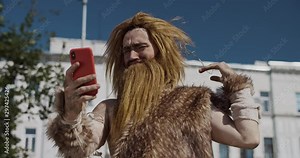 Funny face of neanderthal of hunter-gatherers discovering modern device use mobile phone in modern city civilization cro-magnon evolution future homo sapiens human modern caveman ancient slow motion