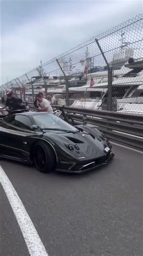 Unos viandantes ayudan a FERNANDO ALONSO a poner en marcha su coche de lujo en MÓNACO