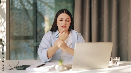 Woman experiences significant wrist pain and discomfort during prolonged computer use, showing distress. Repetitive strain injury from office work causes concern.