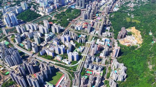 Aerial skyview of Tuen Mun subway extension project in Hong Kong, featuring elevated railway construction along Tuen Mun River and road, new station development and temporary work platforms