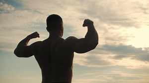 clip-1092216051-bodybuilder-poses-his-back-camera-double-biceps