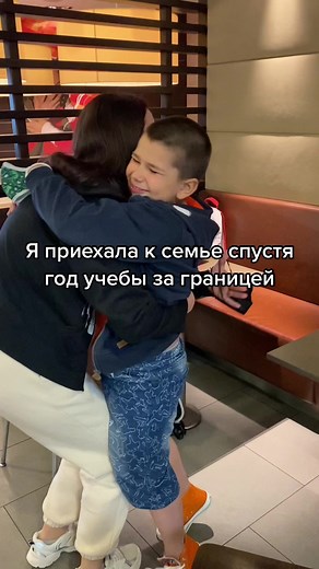 Person in Hooded Sweater Hugs Friend at Fast Food Restaurant