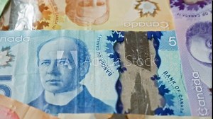 Canadian dollars banknotes featuring various denominations and prominent historical figures show vibrant colorful currency close-up with fine details.