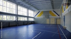 Gym with high ceiling and gleaming hardwood floor. Gym with vibrant floor markings provide organized space for physical education classes