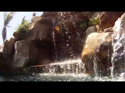 Slide into a Custom Swimming Pool with Natural Stone Waterfalls and Pool Grotto in FL