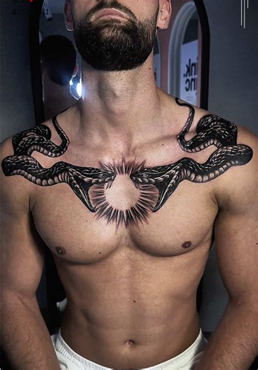 Bold Chest Tattoo Design Featuring Serpents and Sunburst