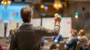 Biomedical ethicist in sharp focus guiding an IRB geneediting session gesturing towards key ethical principles with panelists and charts fading softly out of focus.