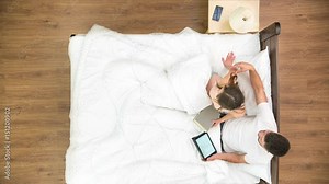 The couple rest all day in the bed. view from above. time lapse