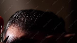 Man Combing His Hair With a Comb Brush in the Slick Back Style in a Cinematic Dark Environment