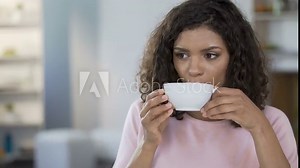 Pretty mixed race woman drinking tea, refusing to add sugar, blood sugar control