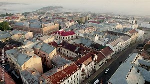 Flying over central part of the city and old houses in Chernivtsi, Ukraine. Aerial drone view of Chernivtsi city, Ukraine in morning lights, little fog on the background