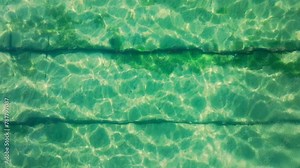 Beneath the surface of Tahoe Lake lies an ethereal underwater railroad, its shadows playing across the lake sunlit bed. Footage 4K.