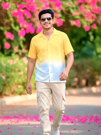 Give the exact same face 8k ultra image.A medium-shot of a smiling man with dark hair and sunglasses, walking on a paved path. He wears a yellow-to-white gradient Cuban collar shirt, cream cargo pants, and white sneakers The background features vibrant pink bougainvillea flowers and lush green foliage with a soft bokeh effect. Falling pink petals are scattered on the ground. Bright natural lighting with a warm, summer aesthetic. The editing style is vibrant with smooth skin textures, high CNY