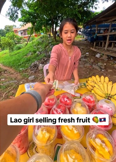 Lao girl selling fresh fruit — street fruit vendor in Laos