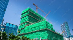 Construction of a skyscraper and green covered fabric construction to protect.