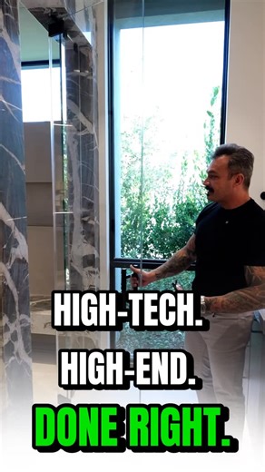 Chakits Krulsawat on Instagram: "As we step into the primary suite, the first thing you notice is the spa-style bathroom with his & hers electronic toilets, book-matched stone cladding, and a zero-threshold steam shower with multiple shower heads. This space was designed for true luxury—LED lighting, dual vanities, a private lounge feel, and 12x24 tile that flows from inside to outside for seamless indoor-outdoor living. The skylight brings in natural light, making the entire primary feel like a