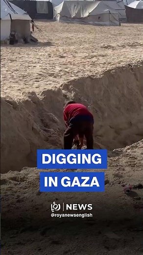 Displaced child builds trench to protect his tent from rainfall