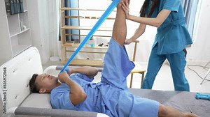 A nurse helps with physical therapy for a male patient at the hospital. Asian male patient receives treatment at medical relief clinic Health insurance concept