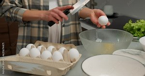 woman's hands in kitchen cracking egg, preparing breakfast Slow motion, girl prepare eggs for omelette or baking banana bread on a light table, closeup cropped shot