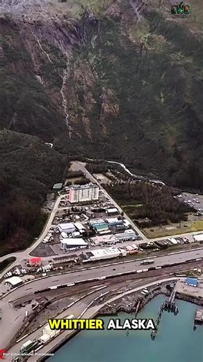 In one of the coldest, windiest corners of Alaska, there’s a town where almost everyone lives inside a single building. It’s called Whittier — population about 237 — and nearly all of them sleep, shop, work, and live inside a 14-story structure called Begich Towers. Outside, the weather is brutal: icy storms, deep snow, and winds that slice across the coast. So the town moved inward. Inside the building you’ll find homes, a store, a post office, a clinic, and even a school connected by an underg