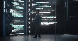 Portrait of Young Woman Working on Laptop Computer, Looking at Big Digital Screen Displaying Back-end Code Lines. Professional Programmer Developing a Big Data Interface Software Project