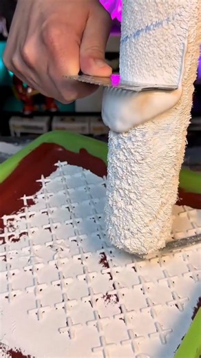 Creating a unique textured pattern on a surface using a roller and thick white plaster