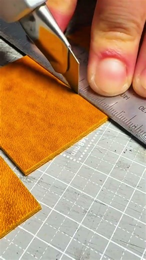 Hands cutting textured orange leather on crafting mat