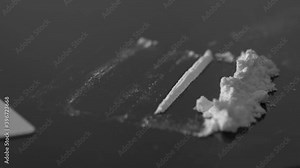 A rolled banknote snorting a line of cocaine powder. Drug Abuse. Sniffing Cocaine lines. White powder on black table. Macro shot.