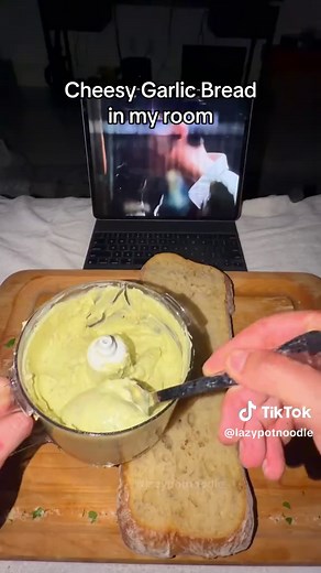 Making Cheesy Garlic Bread in my room! 🧀🧄🥖 — If you’re bad at cooking here’s something really easy to make. What do you you guys think of the new packaging? Get your own on Amazon! Ingredients: • Ciabatta loaf • Lots of Garlic • Olive oil • Mozarella cheese • Parmesan cheese • Parsley • Butter • Salt & pepper • Crushed red pepper • Honey Instructions: 1. Add a lot of garlic to a small saucepan and fully drench it in olive oil, then cook over very low heat until the cloves are soft and spreada
