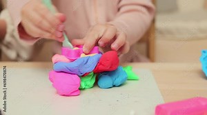 Imaginative play with clay. Child's creative play. Learning motor skills. Unknown two little girls sisters playing with plasticine molding figures in home interior