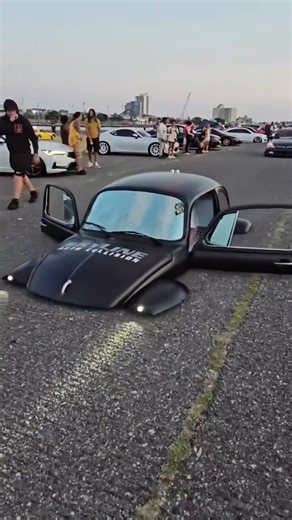 Yeah, I know what you're all thinking: it's not AI. This is a radically modified Volkswagen Beetle custom-built to create the optical illusion of the car "sinking" into the asphalt. | GIGadgets