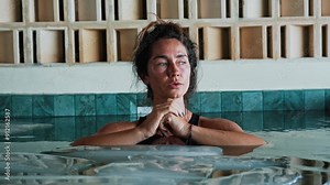 Beautiful Woman Sinking into Cold Water of Swimming Pool with Ice Cubes for Body Health. One Person in Bathtub Filled with Chilled Liquid. Healing Routine of Healthy Sportsman Using Icy Bath Close Up