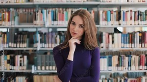 Thoughtful young woman stands before the shelves in the library