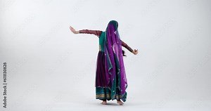 Feel the energy and joy of Bollywood dancing as a young Indian woman dances passionately in a stunning sari with bright colors and patterns, creating an electrifying performance.