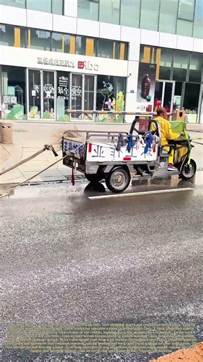 Dragging Water: Sanitation Worker Uses Rope On Tricycle To Wipe Up Road Puddles