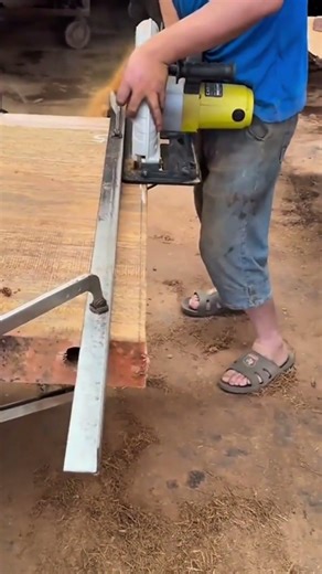 Cutting a thick wooden board using a circular saw with a metal guide for a clean and straight edge