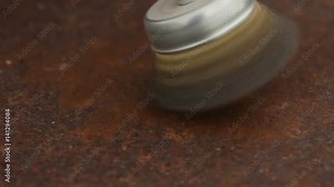 Cleaning a rusty metal sheet with a metal brush