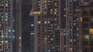 Windows in high-rise building exterior in the late evening with glowing and blinking interior lights on timelapse. Aerial top view Stock Video