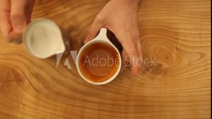 Overhead Shot Of Hands Pouring Steamed Milk Into Latte and Making Simple Fern Pattern