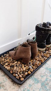 2 years later, and this simple DIY boot tray still looks great! To spot clean, I vacuum around the rocks. To deep clean, I put the rocks in a colainder and wash them along with the mat. We've lost a few rocks over the years, but they're easy to replace. 😅 (Because I always get the comments: NO, don't make this if you have pets or children that poop in rocks, eat rocks, or throw rocks. NO, we have never found mold in the rocks. YES, the rocks help dry out boots faster because the water flows dow