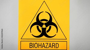 Biohazard sign on laboratory wall. Caution sign for authorised personnel. Yellow warning symbol of chemical contamination, toxic materials. Threat of unknown virus infection. Biological attack danger.