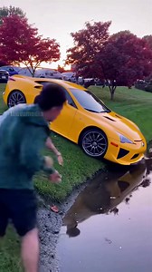 A multi-million dollar Pagani Huayra Roadster rolls down an embankment at a car meet, plunging into a pond despite frantic efforts by two men to stop it. The luxury hypercar rapidly sinks, leaving only bubbles. | Vu Next