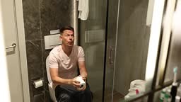 Sad man sitting in toilet with intestinal problems and holding toilet...