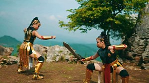 a martial arts master teaches his female apprentice punching moves with a stern expression