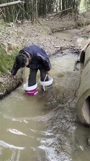 Guy uses plastic buckets as boots to cross the river, so creative!